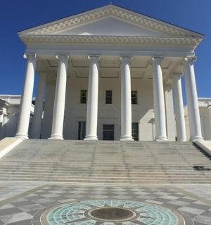 一座白色的大楼，前面有柱子和喷泉