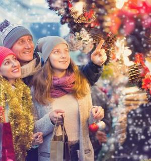 a woman and her daughter standing next to a christmas tree