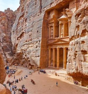 a group of people walking through a canyon