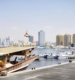 a large boat is docked next to a river with buildings