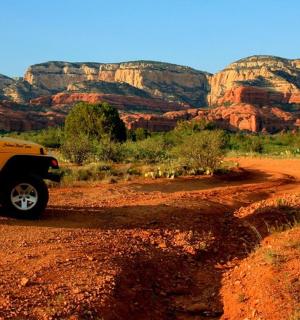 一辆黄色卡车停在沙漠的一条土路上