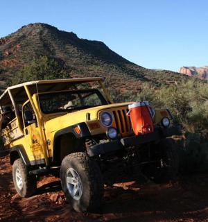 žlutý džíp jedoucí po nezpevněné cestě