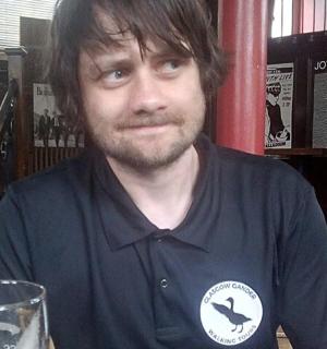 一位男士坐在桌边,手里拿着一杯