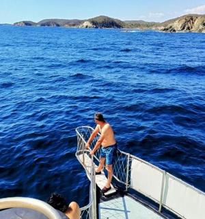 a man standing on the deck of a boat in the water