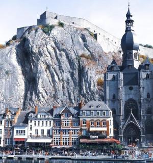 a large building on the water next to a mountain