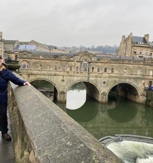 一名男子站在河上的桥上