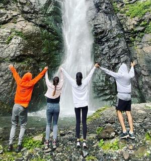 四个人站在瀑布前