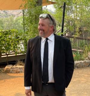 muž v obleku a kravatě se usmívá