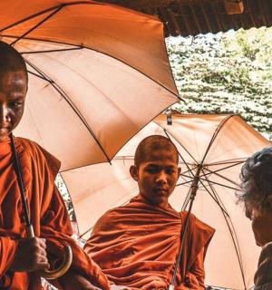 a painting of three monks holding umbrellas