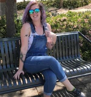 一位戴着太阳镜的女人坐在长椅上