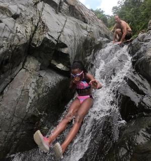 dívka v růžových plavkách na vodopádu