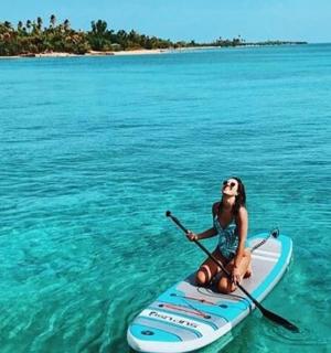 a woman sitting on a paddle board in the water