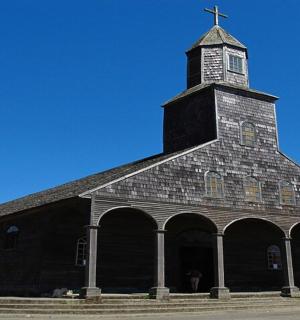 a large black church with a cross on top of it