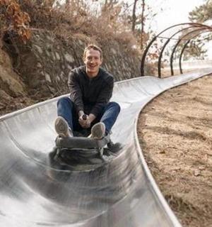 一名男子坐在斜坡上的滑板上