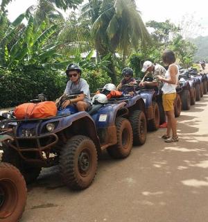 一群人骑着四轮摩托车在土路上行驶