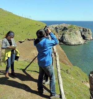 muž fotí ženu fotící oceán