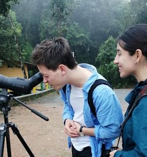 一男一女看着三脚架上的相机