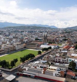 an aerial view of a city with a green field