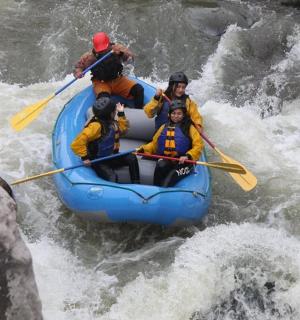 一群人坐在河里的木筏上