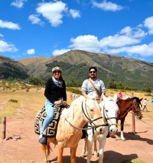 a man and a woman riding horses in a field