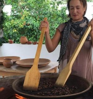 一名妇女拿着锅里的两件木制器具