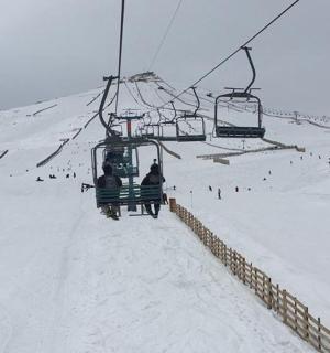 a group of people riding a ski lift in the snow