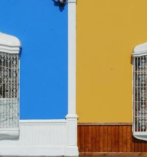 a building with two windows with a bird cage