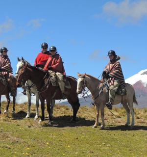a group of people riding horses in front of a mountain