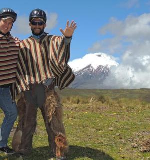 two men standing in a field with a mountain in the background