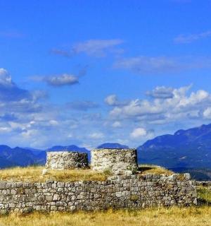 一堵古老的石墙，背景是群山