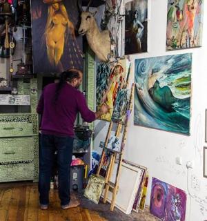 一位女士正在墙上画画