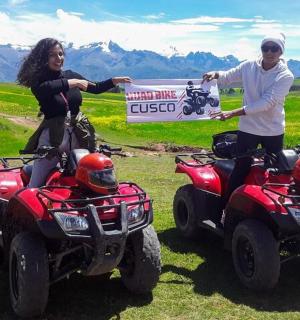 muž a žena stojící vedle čtyřkolek