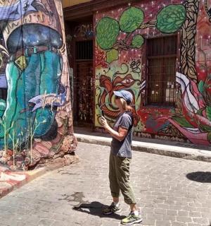 Ein Mann steht vor einem Wandgemälde an einem Gebäude