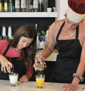 dvě ženy stojící v kuchyni a připravující nápoje