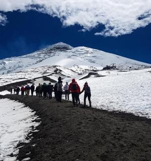 a group of people walking on a snow covered mountain
