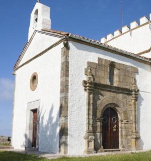 an old white church with a tower on a field