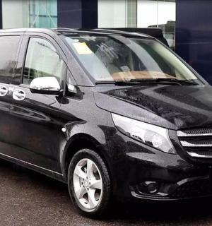 a black minivan parked in a parking lot