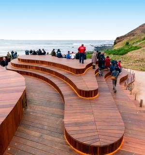 skupina lidí jdoucích po promenádě poblíž pláže