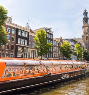 城市河流上的一艘橙色小船