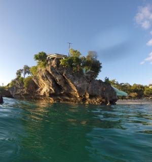 osoba ve vodě před ostrovem