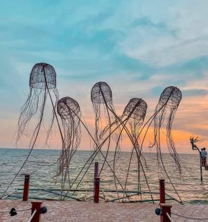 a sculpture on the beach at sunset