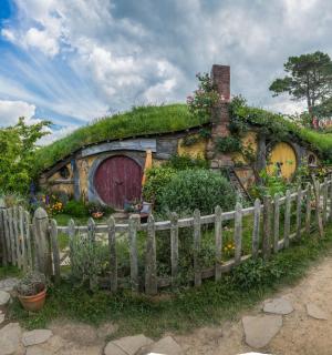 dům se zelenou střechou a plotem