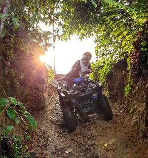 شخص يركب دراجة رباعية على طريق ترابي