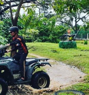 um homem andando de quadriciclo em uma trilha de terra
