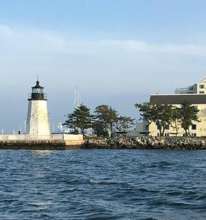a lighthouse on the water with a building
