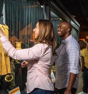 žena se dívá na šaty na věšáku