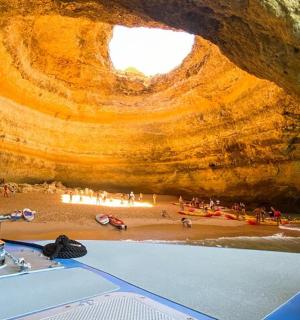 a boat in a cave with a group of people on the beach