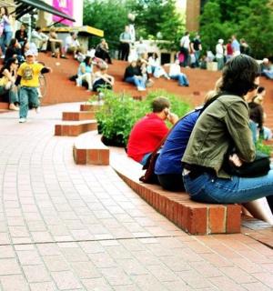 skupina lidí sedících na lavičkách v parku