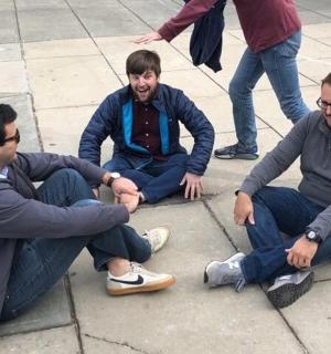 a group of three men sitting on the ground