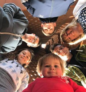 a group of people standing in a circle with a child